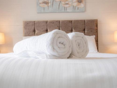 een bed met witte handdoeken erop bij Lodge 10 - The Cedars in Perth