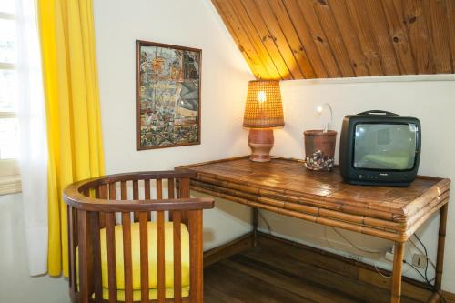 a television sitting on a wooden desk with a lamp at Tsara Guest House in Fianarantsoa