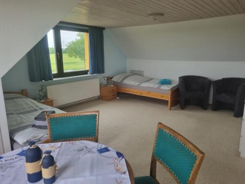 a room with a bed and a table and chairs at Pension Küstenkind in Bentwisch