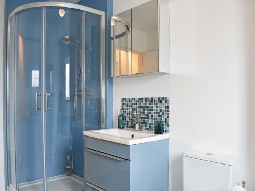 a bathroom with a glass shower and a sink at 6 Twentyman Court in Keswick