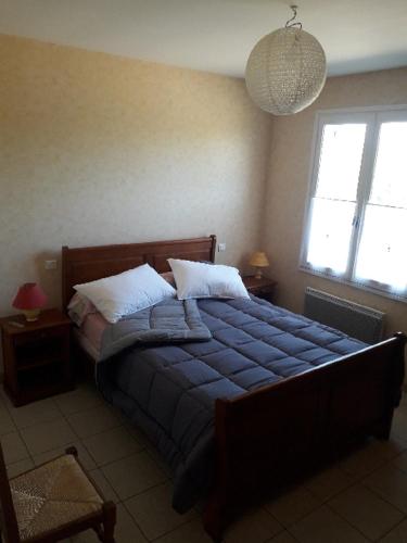 ein Schlafzimmer mit einem großen Bett mit einer blauen Decke in der Unterkunft Gîte du guilhaumard et du larzac in Cornus