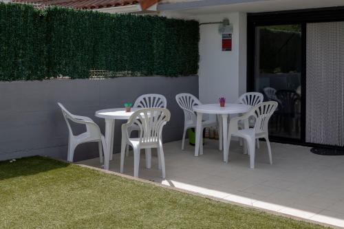 - une table et des chaises blanches sur la terrasse dans l'établissement Suseia, à Zubiri