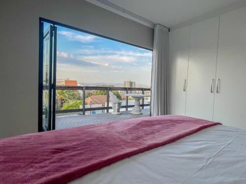 een slaapkamer met een groot raam met uitzicht bij UysTUYS in Kaapstad