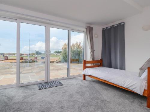 a bedroom with a bed and a large window at Sea La Vie in Lytham St Annes