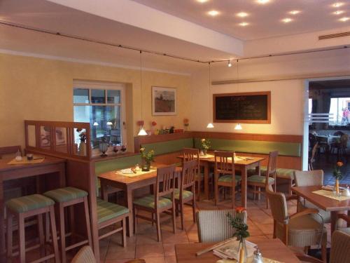 ein Restaurant mit Tischen und Stühlen in einem Zimmer in der Unterkunft Gästehaus Alpin in Bergen