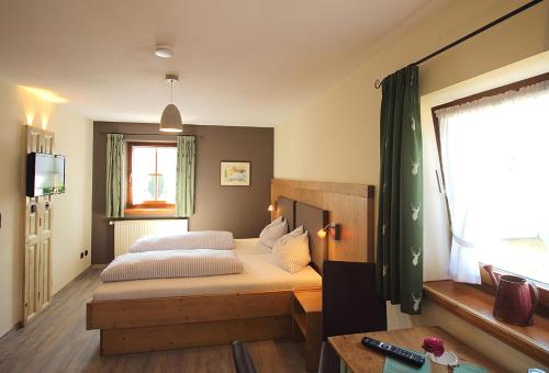 a bedroom with a bed and a television in it at Gästehaus Alpin in Bergen