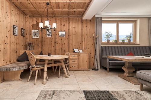 a dining room with wooden walls and a table and chairs at Pension Grünerhof in Sölden