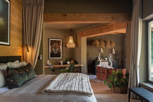 a bedroom with a large bed and a desk at Lush Private Game Lodge in Pilanesberg