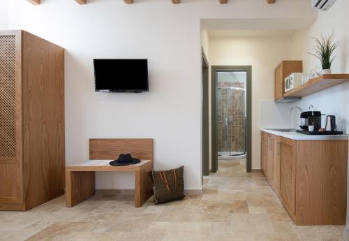 a kitchen with a table and a tv on the wall at Kseynasa Suites in Nikiti