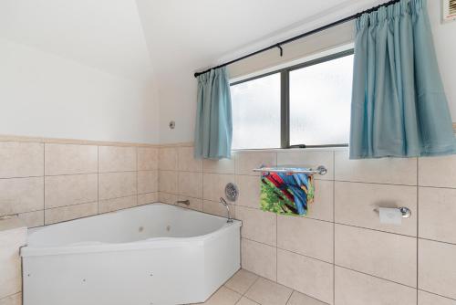 タウポにあるCentral on Tui - Taupo Central Holiday Unitの窓のある浴室の浴槽