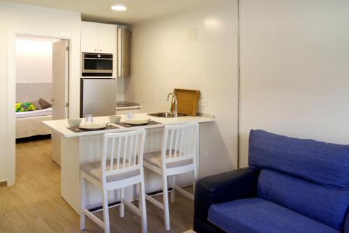 eine Küche mit einer Spüle und einer Theke mit 2 Stühlen in der Unterkunft vallespin 43-1 - céntrico, parking, wifi in Avila