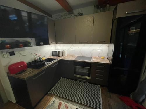 a small kitchen with brown cabinets and a stove at Chata Miško in Snina