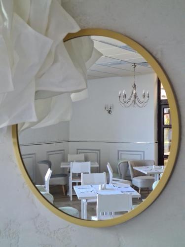 a mirror reflecting a dining room with white tables and chairs at Grand Royal Hotel in Poznań