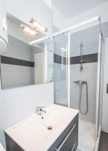 une salle de bain blanche avec un lavabo et une douche dans l'établissement Maison Planté a5, à Argelès-Gazost