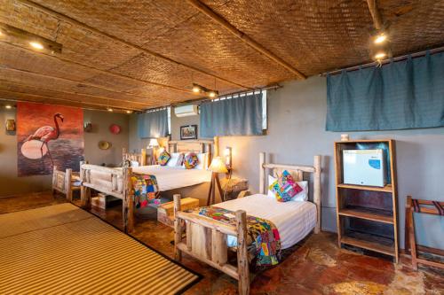 a bedroom with two beds and a flat screen tv at Wag Hill Lodge & Spa in Mwanza