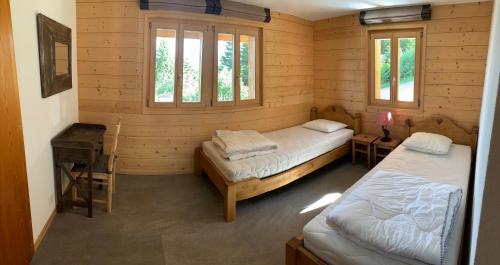 アンゼールにあるChalet Clématitesのログキャビン内のベッド2台が備わる部屋です。