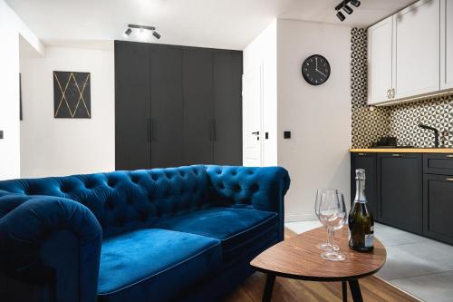 a blue couch in a living room with a table at Apartamenty Piotrkowska 37 Loft w Centrum Łodzi Klimatyzacja in Łódź