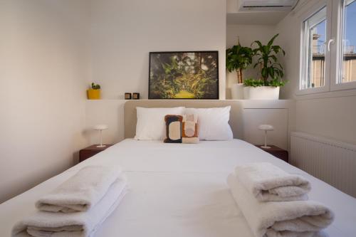 een slaapkamer met een groot wit bed en handdoeken bij The Nest Athens in Athene