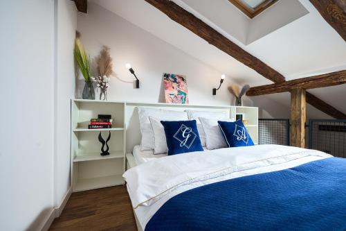 sypialnia z łóżkiem z niebiesko-białymi poduszkami w obiekcie Apartamenty Piotrkowska 37 Loft w Centrum Łodzi Klimatyzacja w Łodzi