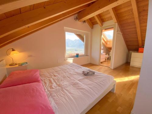 una camera con un grande letto e una grande finestra di Bellavista II Panorama Ferienwohnung mit Pool OG DG a Colico
