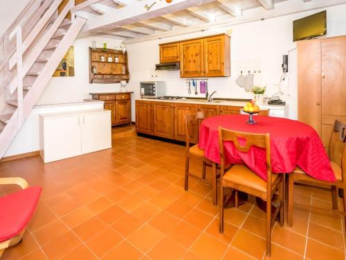 una cucina con tavolo e sedie rossi e una scala di Vento Breva Garten Ferienwohnung a Domaso