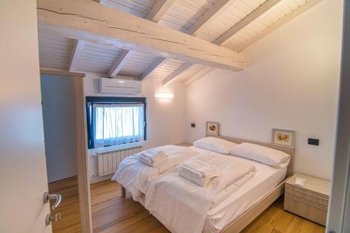 - une chambre avec un grand lit et des draps blancs dans l'établissement Dascio Salute Ferienwohnung mit Panorama Balkon am See, à Dascio