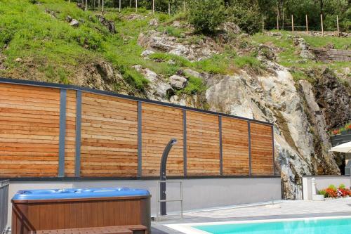 a swimming pool with a wooden fence next to a mountain at Dascio Paradise Ferienwohnung mit Dachterrasse am See in Dascio