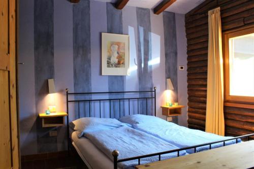 a bedroom with a bed and two lamps on two tables at Bassotta Strand-Blockhaus in Sorico