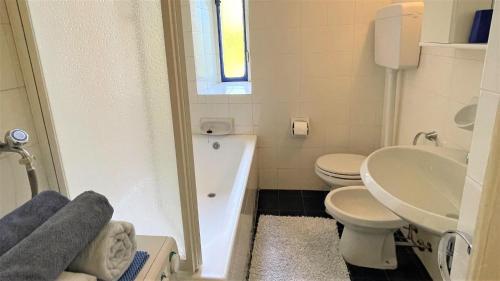 a bathroom with a toilet and a tub and a sink at San Giusto I Villen-Ferienwohnung (EG) in Menaggio
