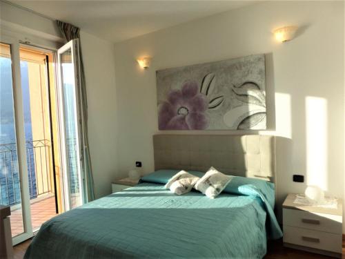 Schlafzimmer mit einem Bett mit Wandgemälde in der Unterkunft Nido di Mariangela See-Ferienwohnung in Bellano