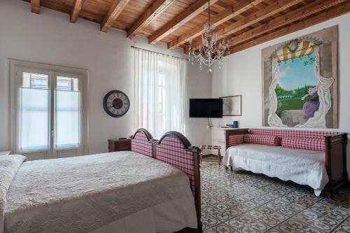 a bedroom with two beds and a couch and a tv at Al Duomo in Lonato del Garda