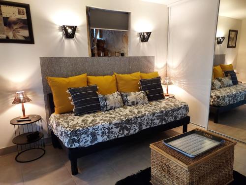 a living room with a couch with yellow pillows at Au Vieux Séchoir in Prudhomat