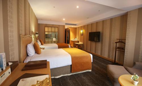 um quarto de hotel com duas camas e um sofá em Chateau de Chine Xinzhuang em Xinzhuang