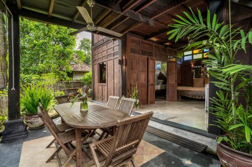 a patio with a wooden table and chairs at Yabbiekayu in Yogyakarta