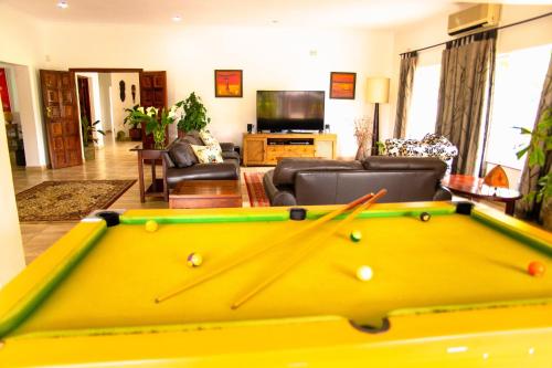 a living room with a pool table in the middle at Burley House by Ulendo in Lilongwe