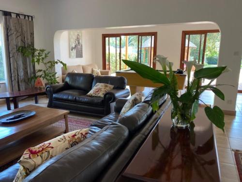a living room with a leather couch and a table at Burley House by Ulendo in Lilongwe