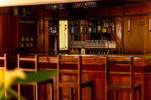 a bar with wooden cabinets and chairs in a room at Burley House by Ulendo in Lilongwe
