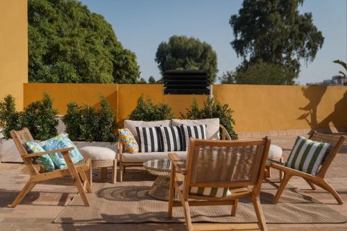 un patio con sillas, un sofá y una mesa en numa I Prestigio Apartments, en Sevilla