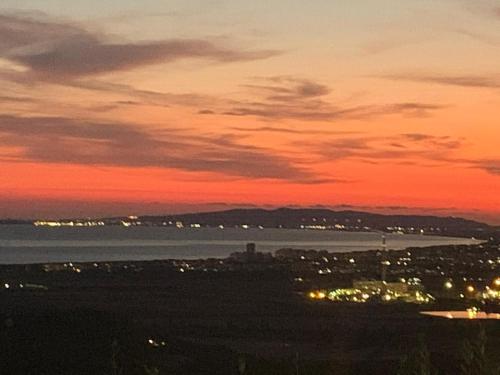 a sunset view of a city and a body of water at La Conchiglia in Scarlino
