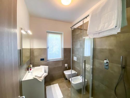 a bathroom with a toilet and a sink and a shower at Paradiso-Boschetto Strand Bungalow mit Pool in Sorico