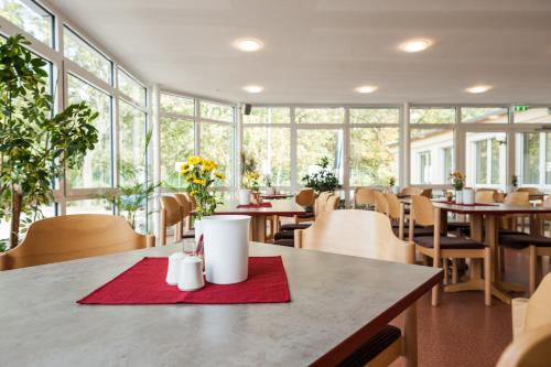 a restaurant with tables and chairs and windows at Sportpension Dresden in Dresden