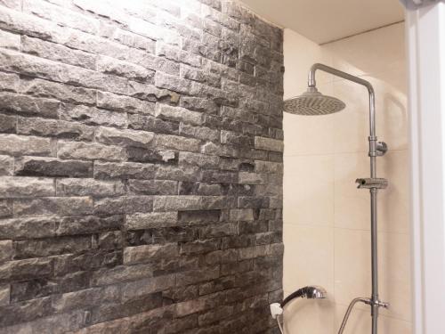 a brick wall in a bathroom with a shower at Jiufen Breeze 九份惠風民宿ｌ6人包棟小屋 in Jiufen