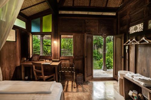 a room with a bedroom with a table and chairs at Yabbiekayu in Yogyakarta