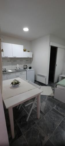 a kitchen with a table in the middle of a room at Studio apartman Centar in Varaždin