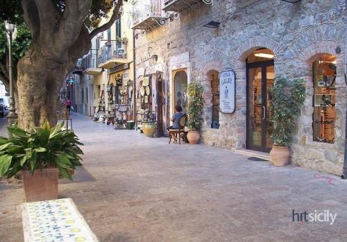 a person sitting on a chair on a street at THE PALACE B&B and Apartments in Santo Stefano di Camastra