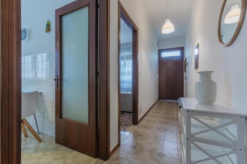 a hallway with a door and a table and a mirror at Ferrara Charming apt 4 min walk from the bus stop! in Ferrara