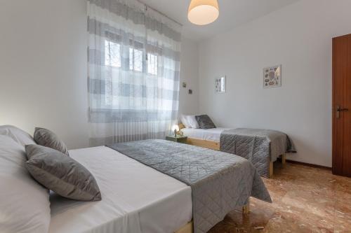 a hotel room with two beds and a window at Ferrara Charming apt 4 min walk from the bus stop! in Ferrara