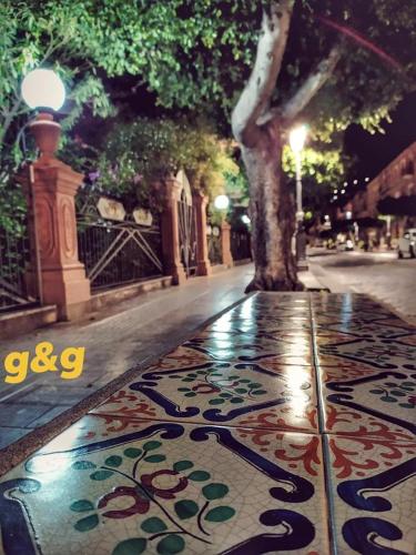 a sidewalk with a rug on the street at night at THE PALACE B&B and Apartments in Santo Stefano di Camastra