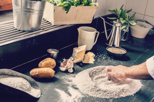 a person kneading dough on a counter in a kitchen at Hotel Tremoggia in Chiesa in Valmalenco