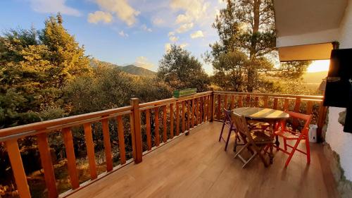 een balkon met een tafel en stoelen en uitzicht bij Hobbiton. Chalet de ensueño en la Sierra de Madrid. in Boalo